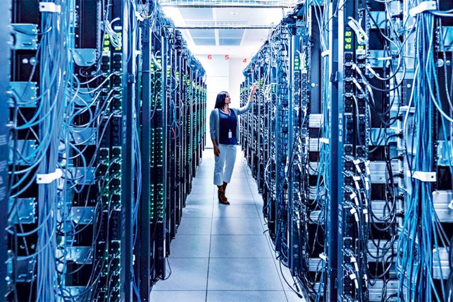 Woman standing in aisle of server room