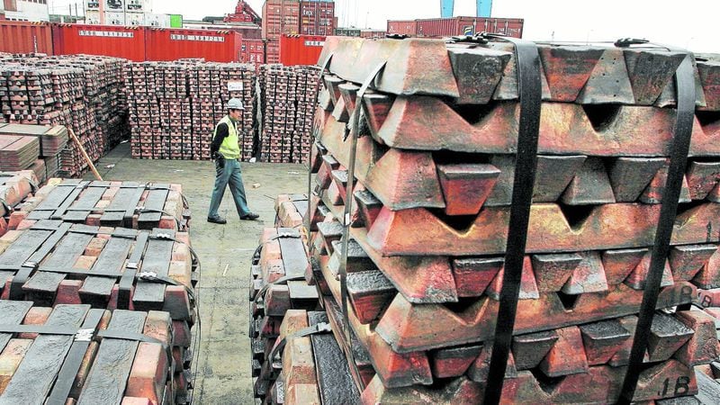 A security guard walks past a shipment of copper that is to be shipped to Asia in  Valparaiso port in Chile