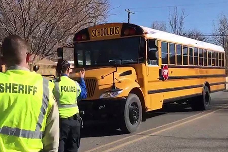 Police escort buses moving students and faculty from Aztec High Schoo