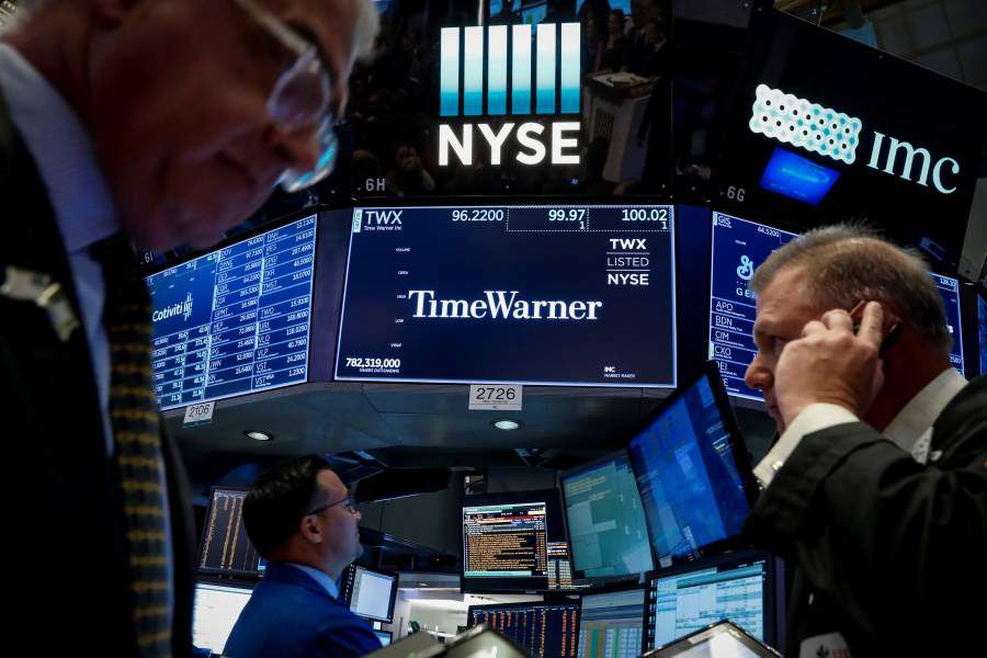 Traders work at the post where Time Warner is traded on the floor of the NYSE in New York