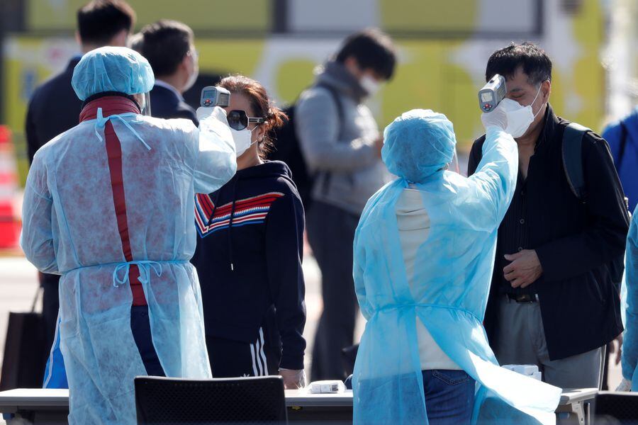 Passengers wearing masks leave cruise ship Diamond Princess at Daikoku Pier Cruise Terminal in Yokohama