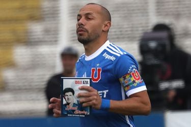 Marcelo Díaz entra a la cancha con un ejemplar de Ídolo Azul, biografía de Leonel Sánchez cuyo autor es Sergio Zarricueta.