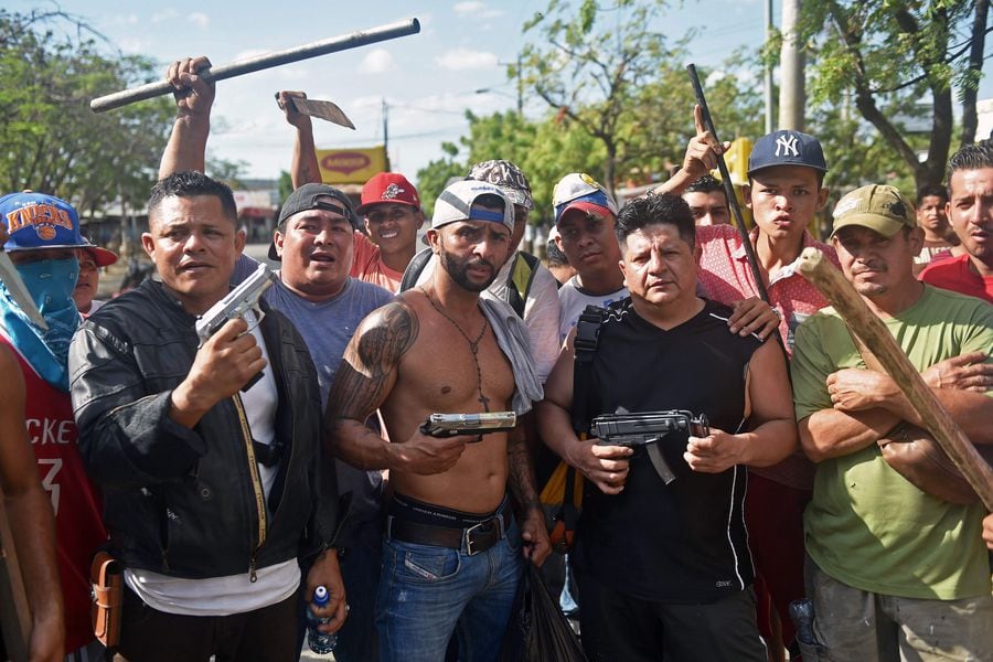 Armed shop keepers of "Mercado Mayoreo" supermarket guard their busin