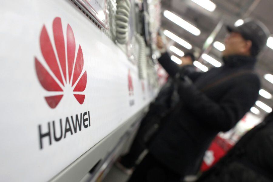 A man looks at a Huawei mobile phone as he shops at an electronic market in Shanghai