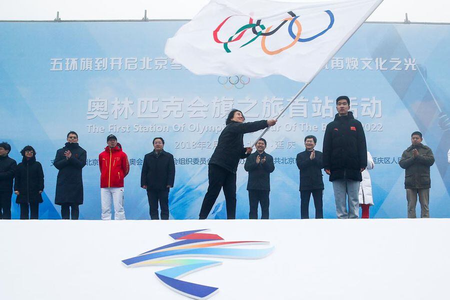 Secretary General of the Beijing Organizing Committee for the 2022 Olympic and Paralympic Winter Games Han Zirong waves the Olmypic flag during a handover ceremony in Beijing