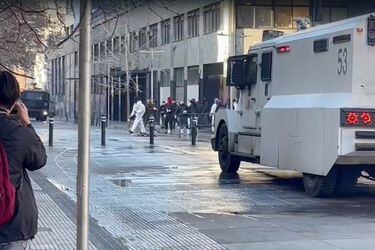 Se registran incidentes afuera del Instituto Nacional: sujetos vestidos con overoles blanco se enfrentan a Carabineros