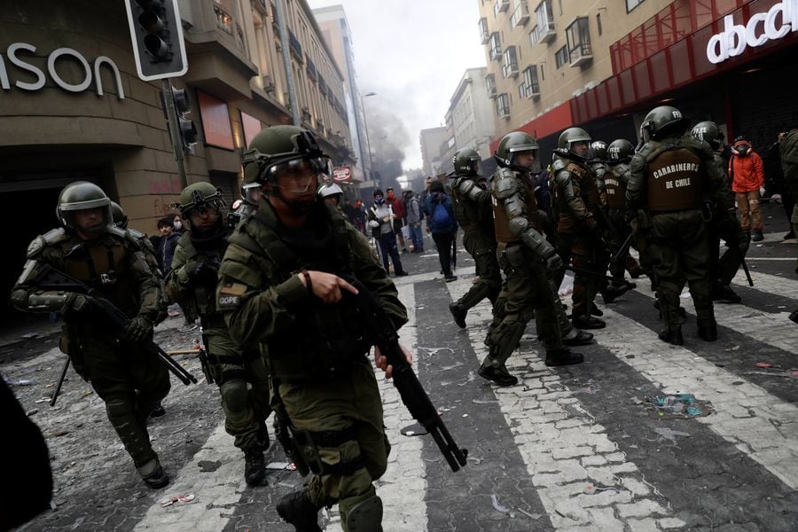 Riot policemen patrol during a protest against Chile's state economic model in Concepcion