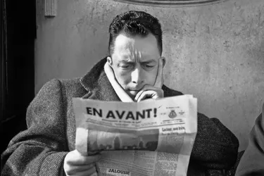 Albert Camus leyendo el periódico.
