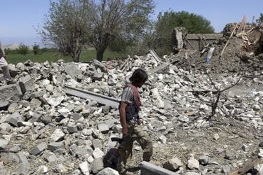 An Afghan security police walks at the destroyed house after an opera