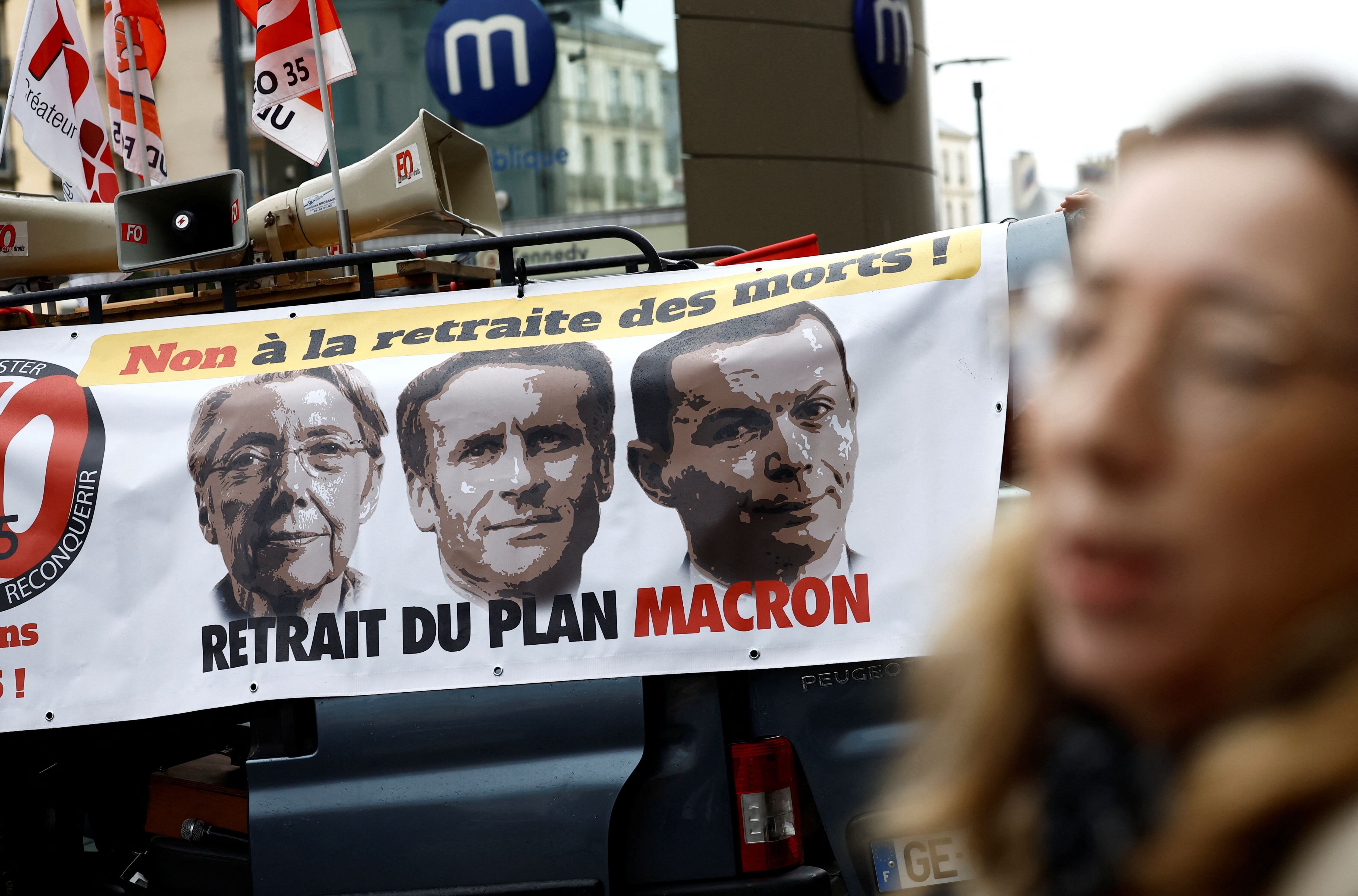 Manifestantes despliegan una pancarta que representa a la primera ministra francesa, Élisabeth Borne; al Presidente Emmanuel Macron y al ministro del Trabajo, Olivier Dussopt, durante una protesta contra la reforma de las pensiones en Rennes, el 10 de enero de 2023. Foto: Reuters