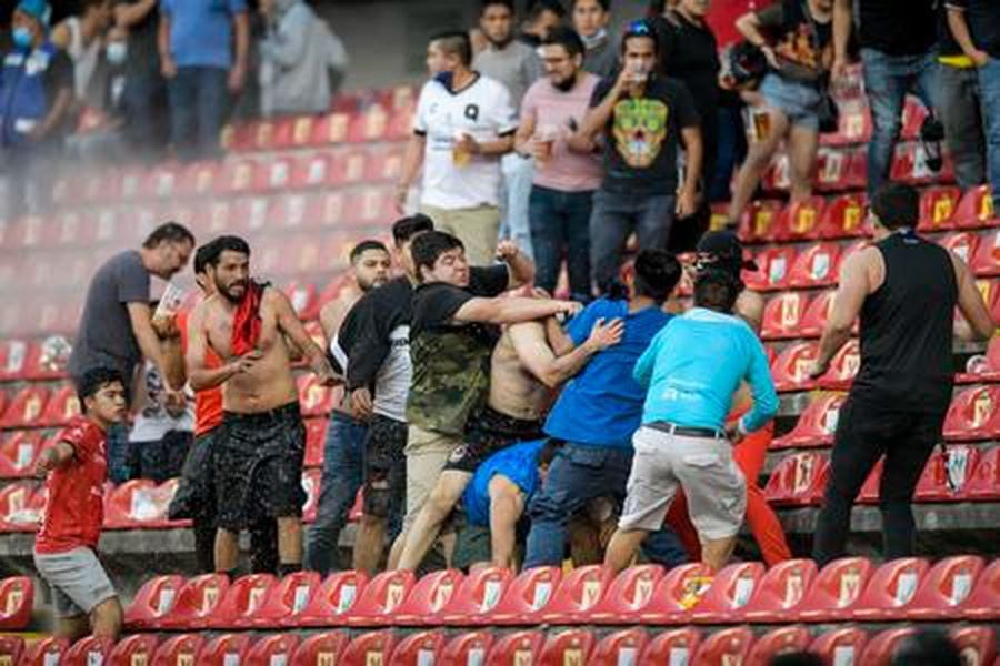 Hinchas peleando en el estadio de Querétaro. Foto AP.