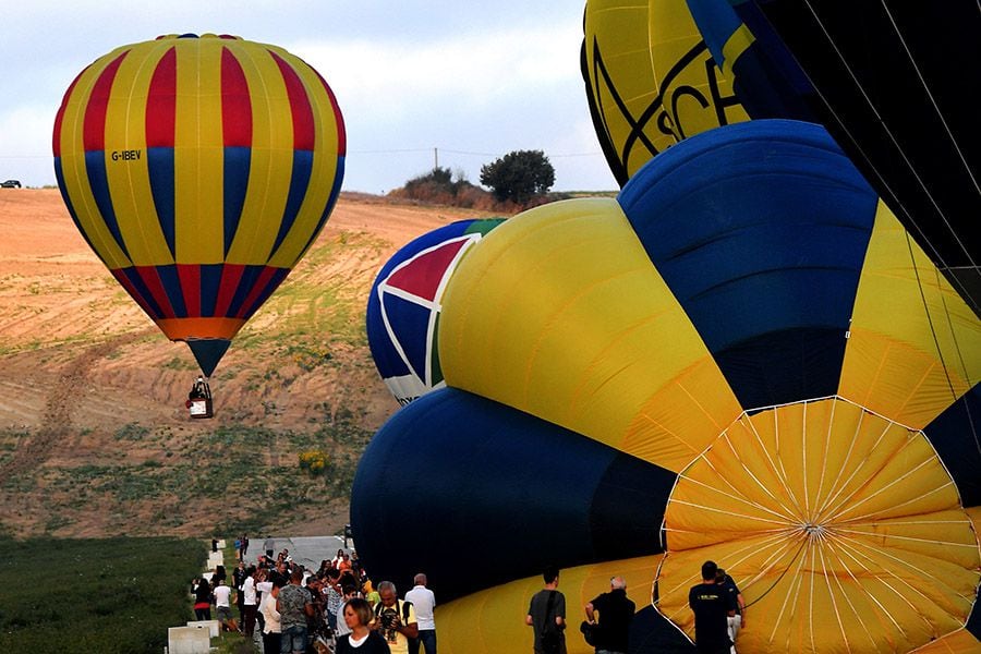 People watch as hot-air balloons prepare for take-off for the sagrant