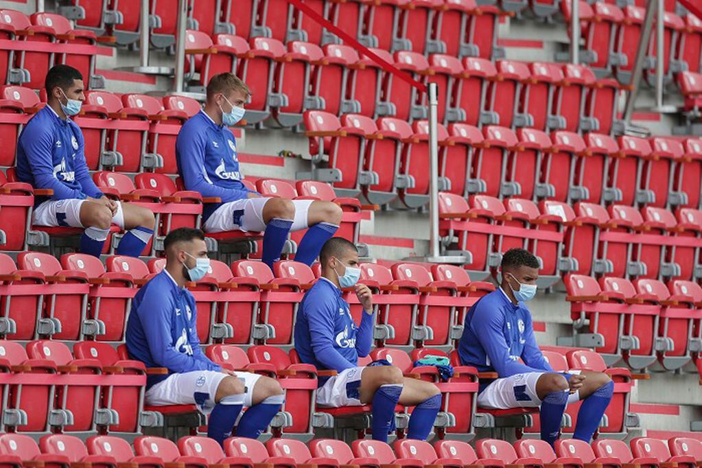 Schalke alternate players sit on the bench during the German Bundesliga soccer match between 1. FC Union Berlin and FC Schalke 04 in Berlin, Germany, Sunday, June 7, 2020. The German Bundesliga is the world's first major soccer league to resume after a two-month suspension because of the coronavirus pandemic. (AP Photo/Michael Sohn, Pool)