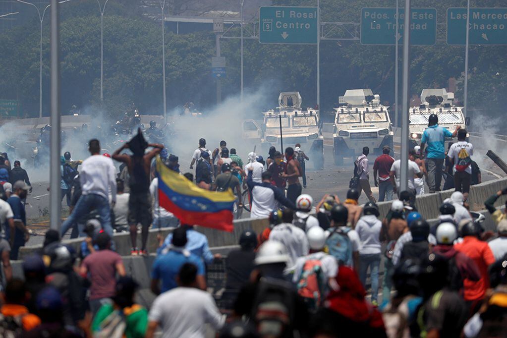 Opposition demonstrators face military vehicles near the Generalisimo Francisco de Miranda Airbase "La Carlota" in Caracas, Venezuela April 30, 2019. REUTERS/Carlos Garcia Rawlins