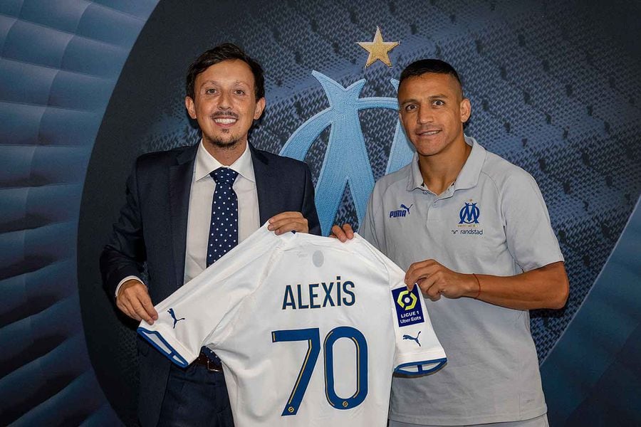 Alexis Sánchez sostiene la camiseta 70 del Olympique de Marsella junto al presidente del club Pablo Longoria.