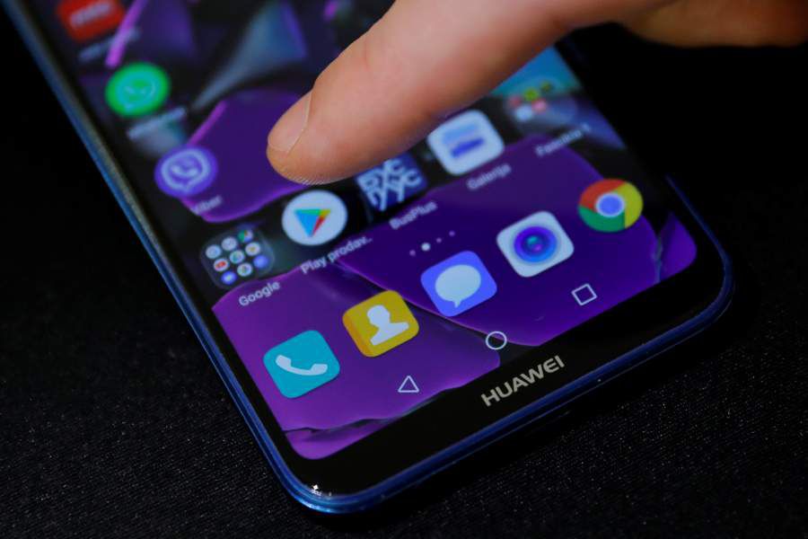 Man points a finger to the Google Play app logo on his Huawei smartphone in this illustration picture