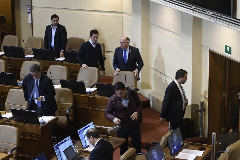 Diputados de la UDI y del Partido Republicano salen de la sala durante el minuto de silencio por el histórico timonel del Partido Comunista Guillermo Teillier.