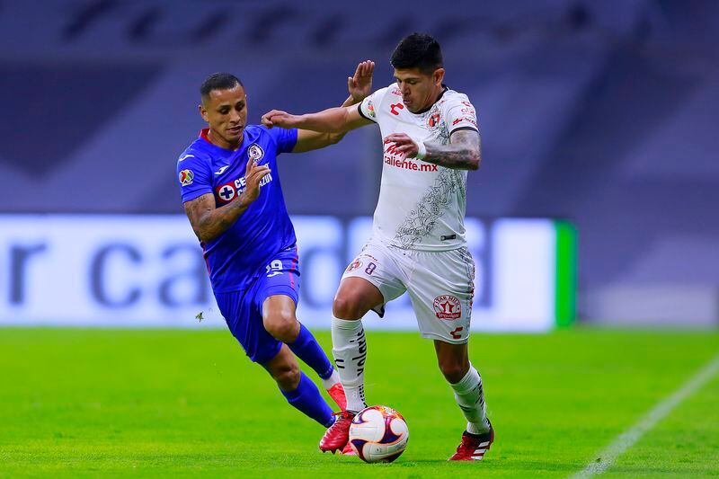 Yoshimar Yotún disputa un balón con Esteban Pavez, cuando ambos militaban en la Liga MX.