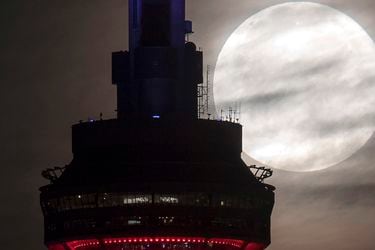 The supermoon sets behind the CN tower in Toronto on Monday, Nov.