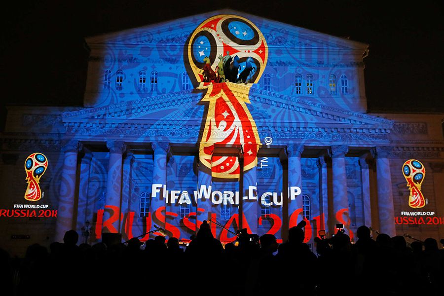 Journalists look at a light installation showing the official logotype of the 2018 FIFA World Cup during its unveiling ceremony at the Bolshoi Theater building in Moscow