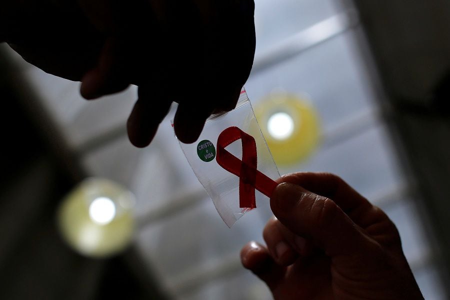 FILE PHOTO: Nurse gives a red ribbon to a woman to mark World Aids Day at the entrance of Emilio Ribas Hospital, in Sao Paulo