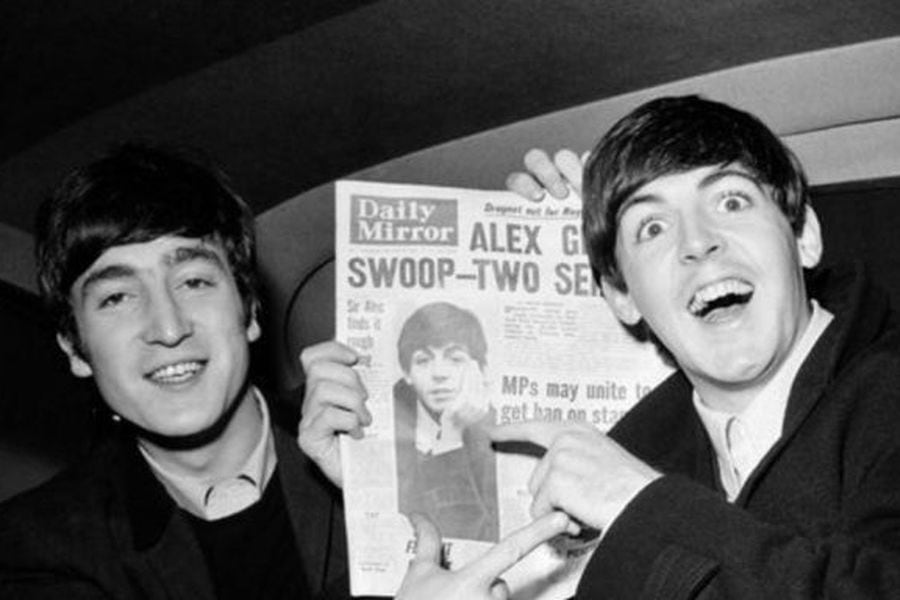 John Lennon y Paul McCartney sosteniendo un diario.