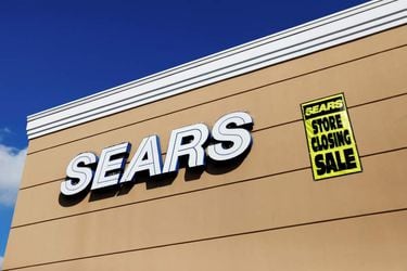 FILE PHOTO: A store closing sale sign is posted next to a Sears logo in New Hyde Park, New York