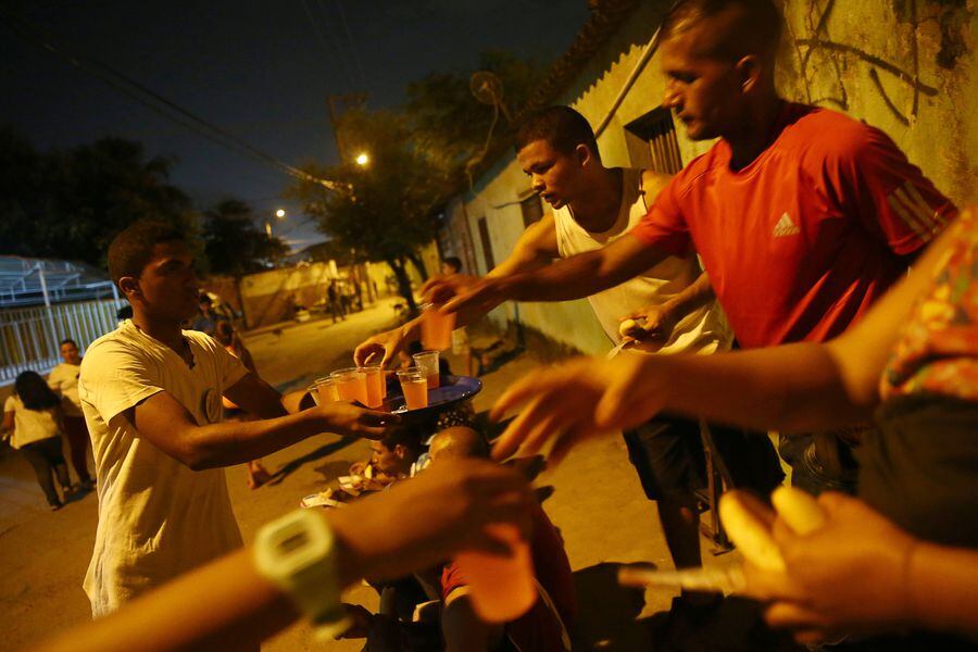 A group of Venezuelans receive help from an evangelical church along a street on the outskirts of Cucuta