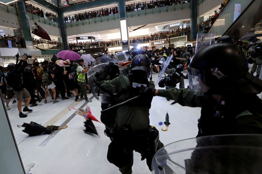 Protesters throw umbrellas at riot police during a clash inside a mall after a march at Sha Tin District of East New Territories, Hong Kong