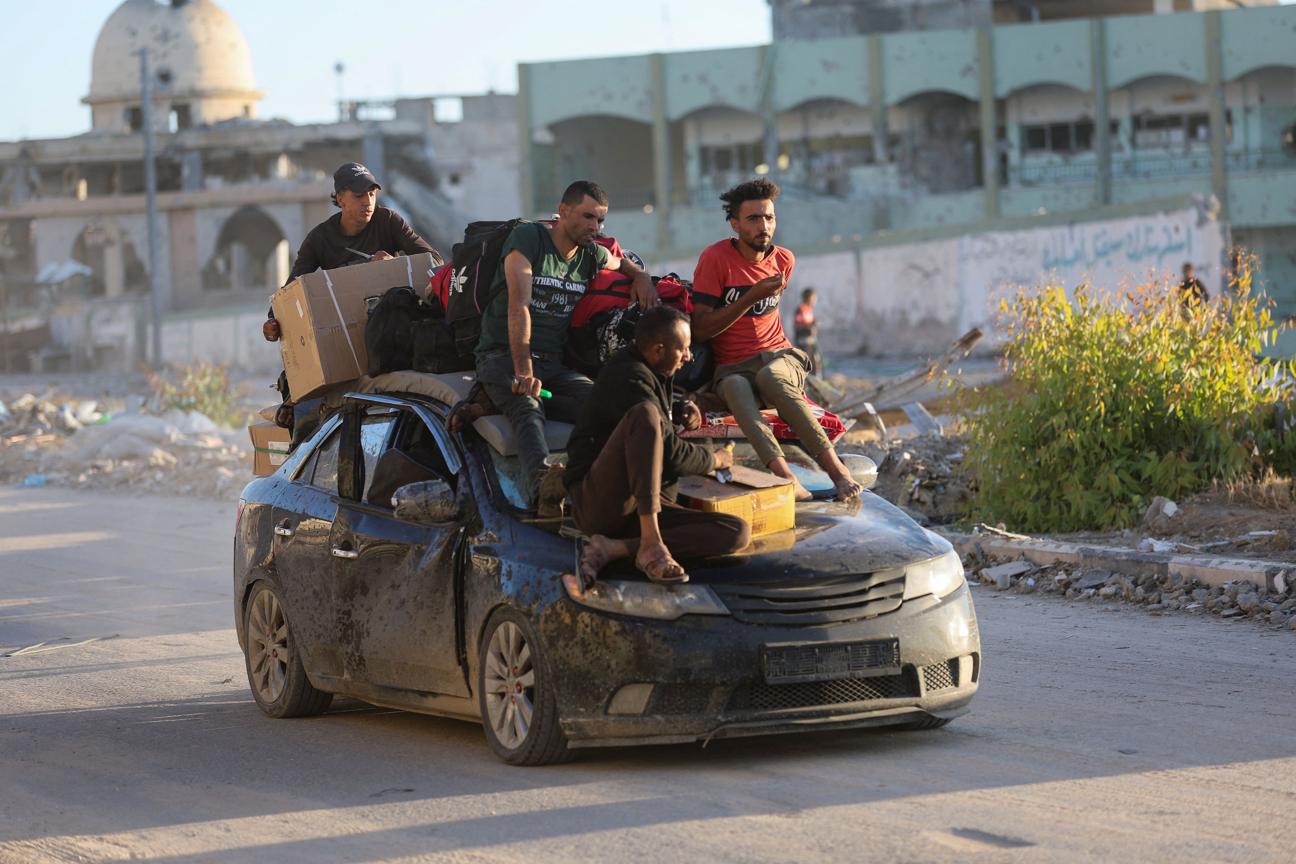 Palestinos desplazados que huyeron de Rafah se sientan en la parte trasera de vehículos con sus pertenencias, en Khan Younis, en el sur de la Franja de Gaza, el 6 de mayo de 2024. Foto: Reuters