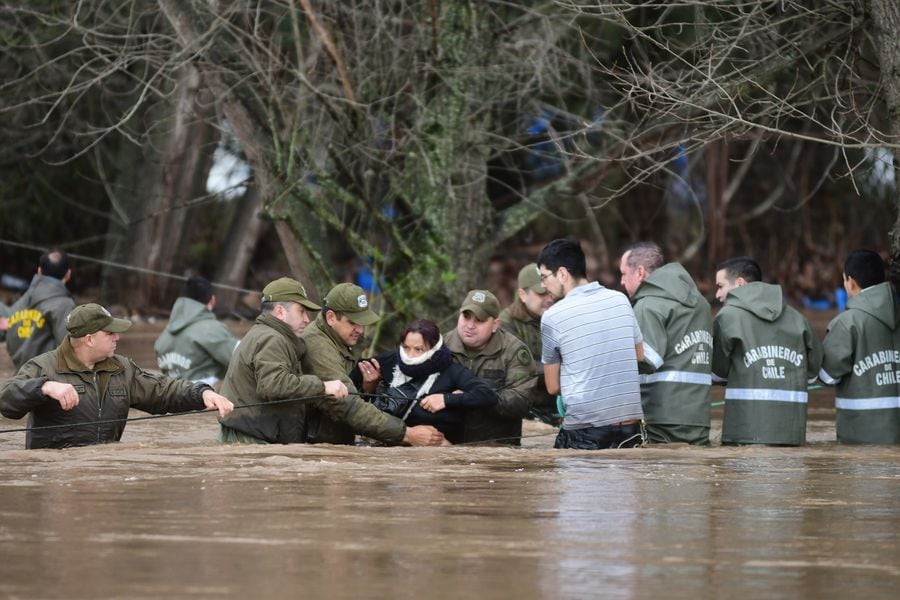Personal de Carabineros ejecuta el rescate de vecinos en el borde del río Claro, en Talca.