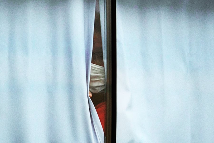 una mujer encerrada y mirando la ventana