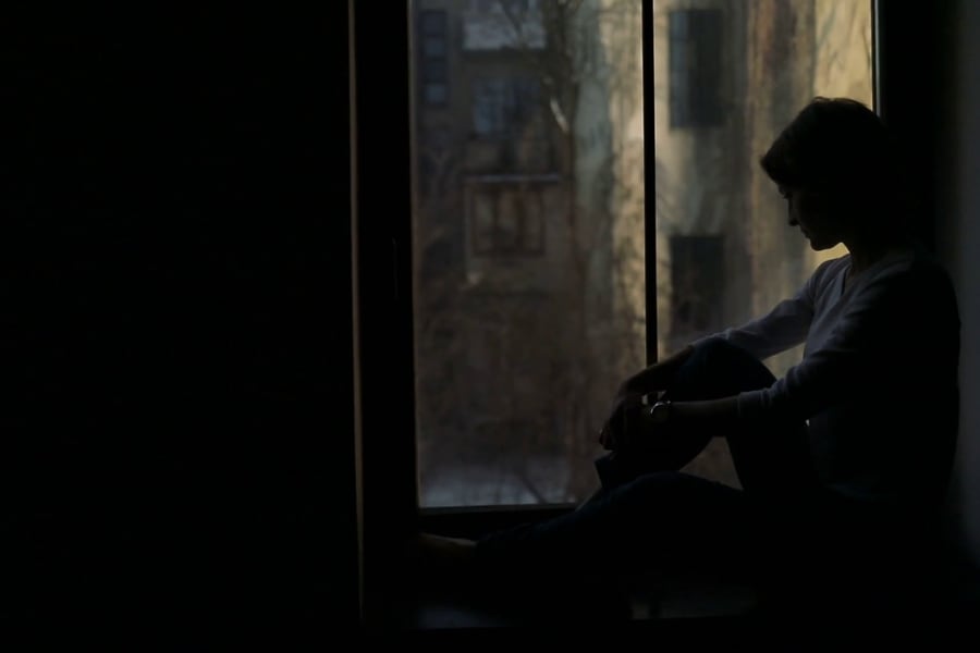 videoblocks-silhouette-of-sad-woman-sitting-on-the-sill-and-looking-out-the-window_hwqxdxial_thumbnail-full01