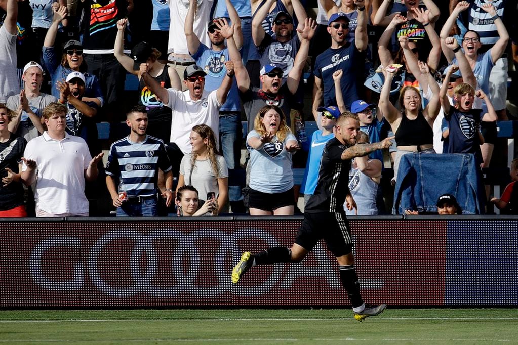 FILE - In this May 26, 2019, file photo, Sporting Kansas City forward Johnny Russell celebrates after scoring a goal during the first half of an MLS soccer match against the Seattle Sounders, in Kansas City, Kan. Many professional sports league, such as the NFL and European soccer leagues, have lucrative television contracts and big-money corporate sponsors that fill their substantial coffers. But the domestic soccer league in the U.S. still relies heavily on ticket sales, merchandising and concessions, much like many university athletic departments, and without games their very ability to make ends meet would stretch the abilities of even the savviest of accountants.(AP Photo/Charlie Riedel, File)
