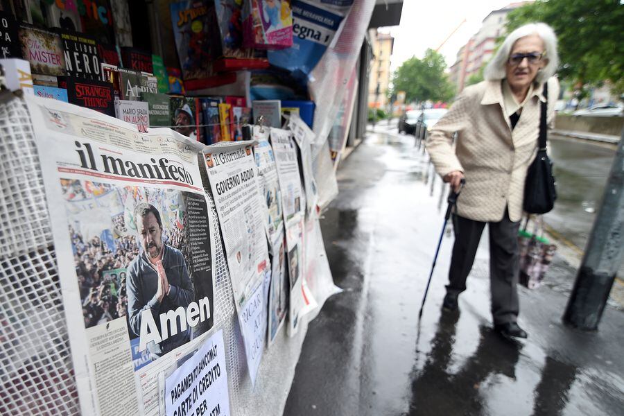 A woman walks past a newsstand which displays copies of Italian daily newspapers with front pages about the rise of the far-right League party in Sunday's European parliamentary election in Milan
