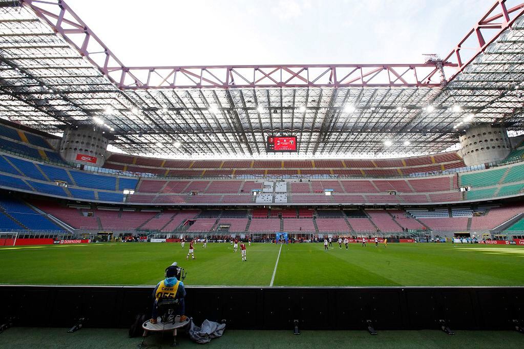 FILE - In this Sunday, March 8, 2020 filer, a view of the empty stadium during the Serie A soccer match between AC Milan and Genoa at the San Siro stadium, in Milan, Italy. While soccer leagues around Europe are still debating whether and when to resume playing, the leader of the continent’s Federation of Sports Medicine Associations is calling for a detailed series of tests to clear athletes for a return to training. Maurizio Casasco, who is also president of the Italian Federation of Sports Medicine, said that guidelines recently published by his domestic federation should be extended for all of Europe -- especially if UEFA intends to resume the Champions League and Europa League anytime soon. (AP Photo/Antonio Calanni, File)