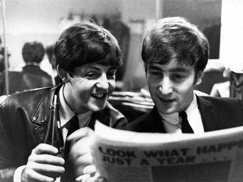Paul McCartney y John Lennon leyendo el diario.