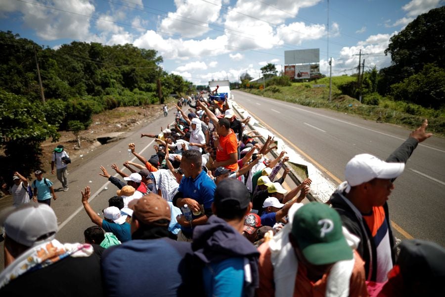 A caravan of migrants trying to reach the United States hitchhike on a truck along the highway in Tapachula