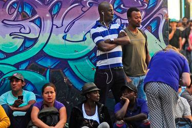 Migrantes extiende lienzo en frente de las oficinas de migracion