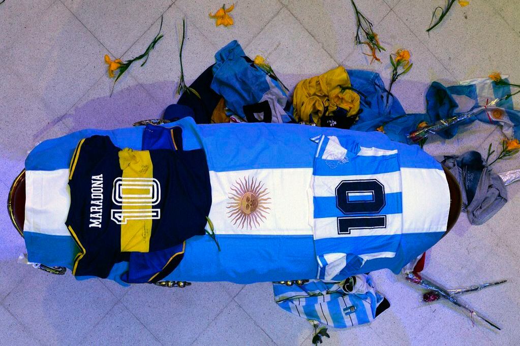 In this photo released by Argentina's Presidency the coffin with the remains of Diego Maradona lies in state inside the presidential palace in Buenos Aires, Argentina, Thursday, Nov. 26, 2020. The Argentine soccer great who was among the best players ever and who led his country to the 1986 World Cup title died from a heart attack at his home Wednesday. He was 60. (Argentina's Presidency via AP)