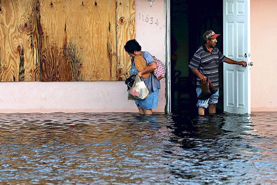 na pareja deja su casa inundada luego del paso de Irma, en Fort Myers, Florida.