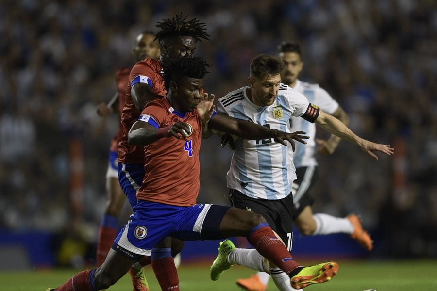 Argentina's Lionel Messi (R) vies for the ball with Haiti's Ricardo A