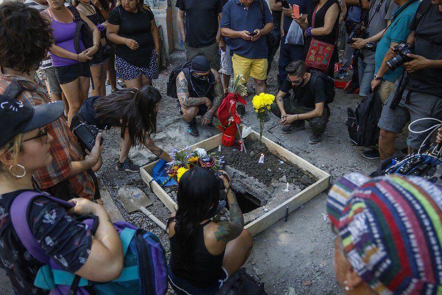 Un grupo de personas, llegan con flores y le rinden un homenaje al manifestante que falleció electrocutado Mauricio Fredes, al caer a una fosa, cerca del sector de Plaza Baquedano.