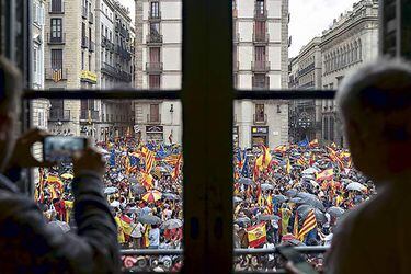 Clientes de un café observan la marcha por la unidad de España el 30 de septiembre en Barcelona.