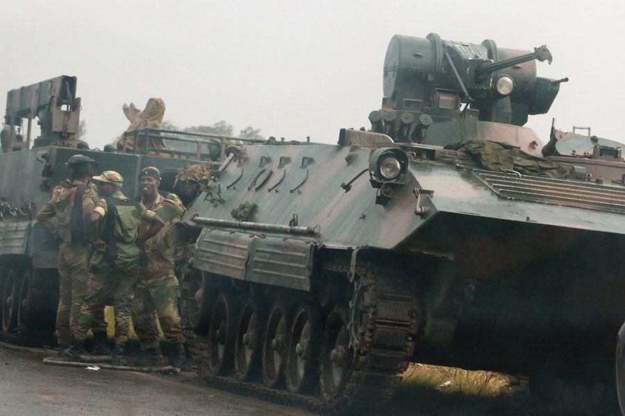 Soldiers stand beside military vehicles just outside Harare, Zimbabwe