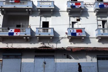 A man walks by a building decorated with Panamanian national flags du