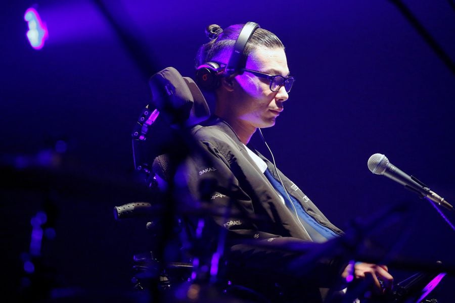 DJ Masatane Muto, diagnosed with the amyotrophic lateral sclerosis (ALS), mixes music using a smart eyewear called 'Jins Meme' which detects eye and head movements, during his performance on the stage in Tokyo