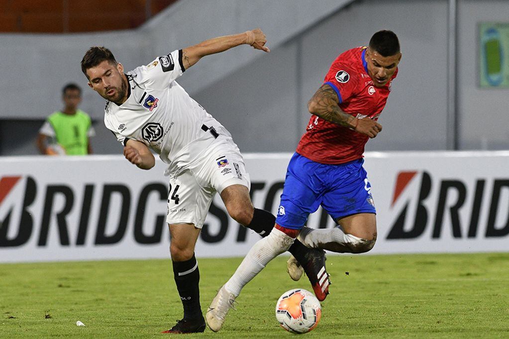 Bolivia's Jorge Wilstermann midfielder Cristian Chavez and Chile's Colo Colo midfielder Cesar Fuentes  vie for the ball during their Copa Libertadores football match, at the Felix Capriles stadium in Cochabamba, Bolivia, on March 4, 2020. (Photo by AIZAR RALDES / AFP)