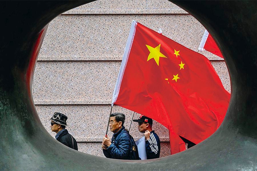 Activists shout slogans while holding China's flag as they gather outside the building that houses the Japanese embassy in Hong Kong on December 13, 2018, to mark 81 years since the 1937 Nanjing massacre. China says 300,000 people died in a six-week spree of killing, rape and destruction by the Japanese military that began in December 1937 after invading troops seized the city of Nanjing. Some respected foreign academics estimate a lower number of victims, but mainstream scholarship does not question that a massacre took place. / AFP / ANTHONY WALLACE   HONG KONG-CHINA-JAPAN-HISTORY-WWII-NANJING-WAR