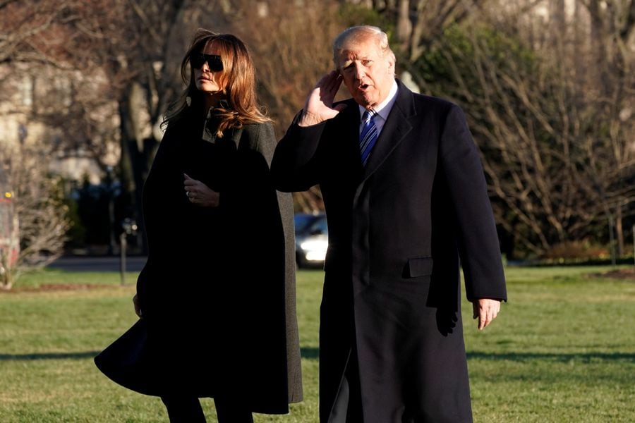 U.S. President Donald Trump listens to reporters as walks with first lady Melania Trump on South Lawn of the White House upon their return to Washington, U.S., from Palm Beach